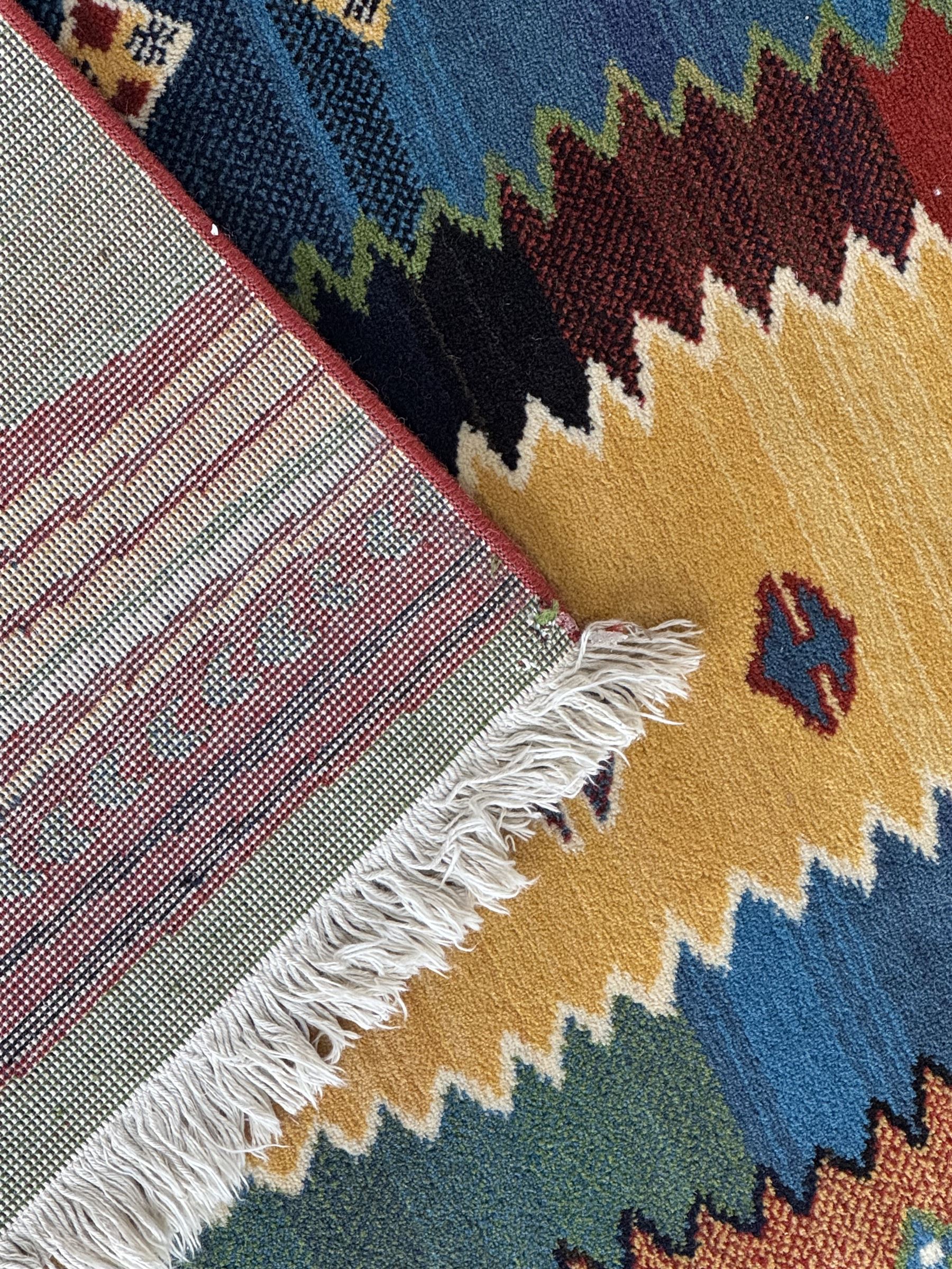 Late 20th century Louis De Poortere Belgian Shalamar wool ground rug, featuring a vibrant multi-coloured geometric design with stacked rectangular borders surrounding two central medallions, finished with fringed ends