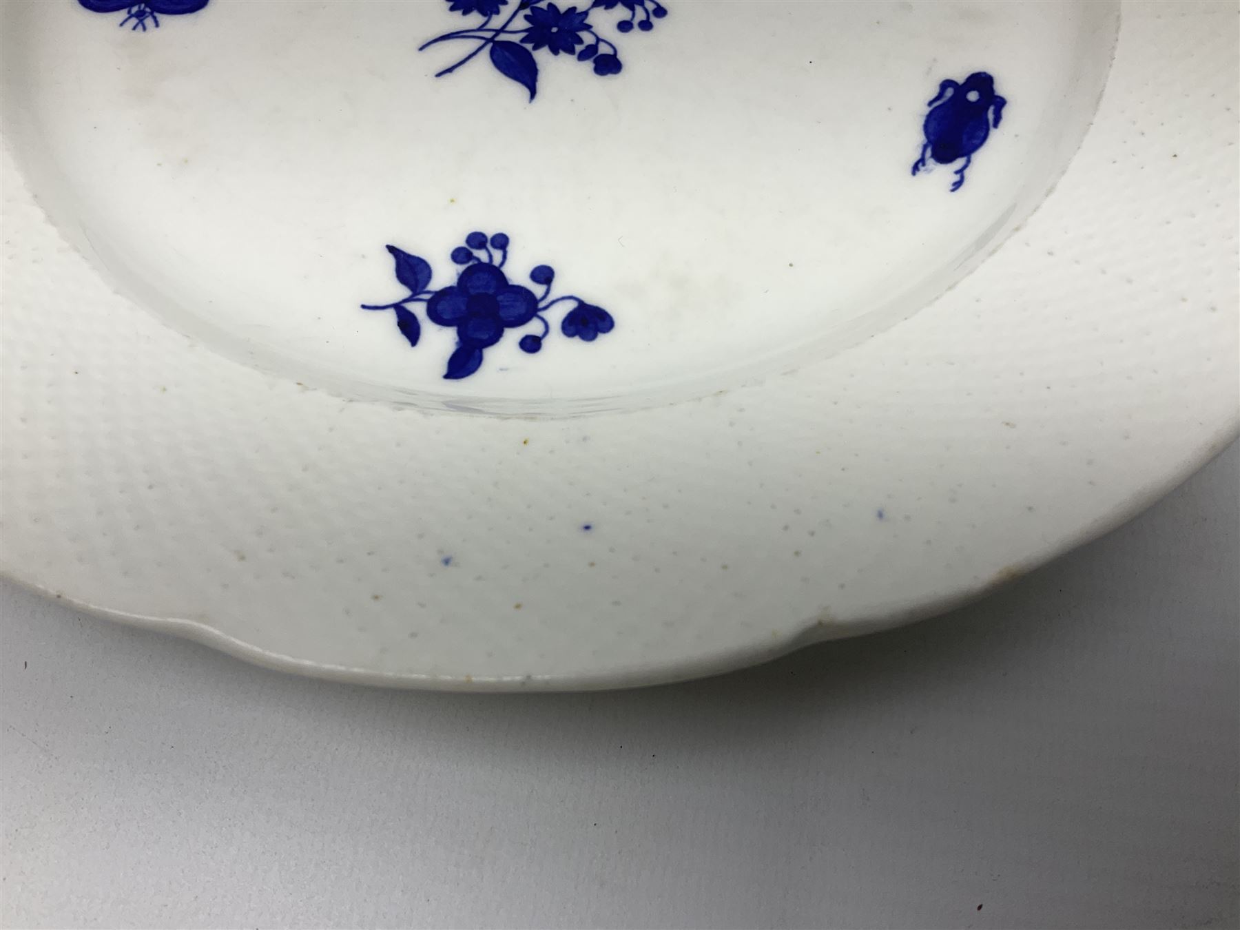 Three 19th century plates, comprising two circular examples and one oblong, each with osier moulded sides, the centres decorated in underglaze blue with Gillyflower type pattern, circular examples D25cm oblong example W27cm