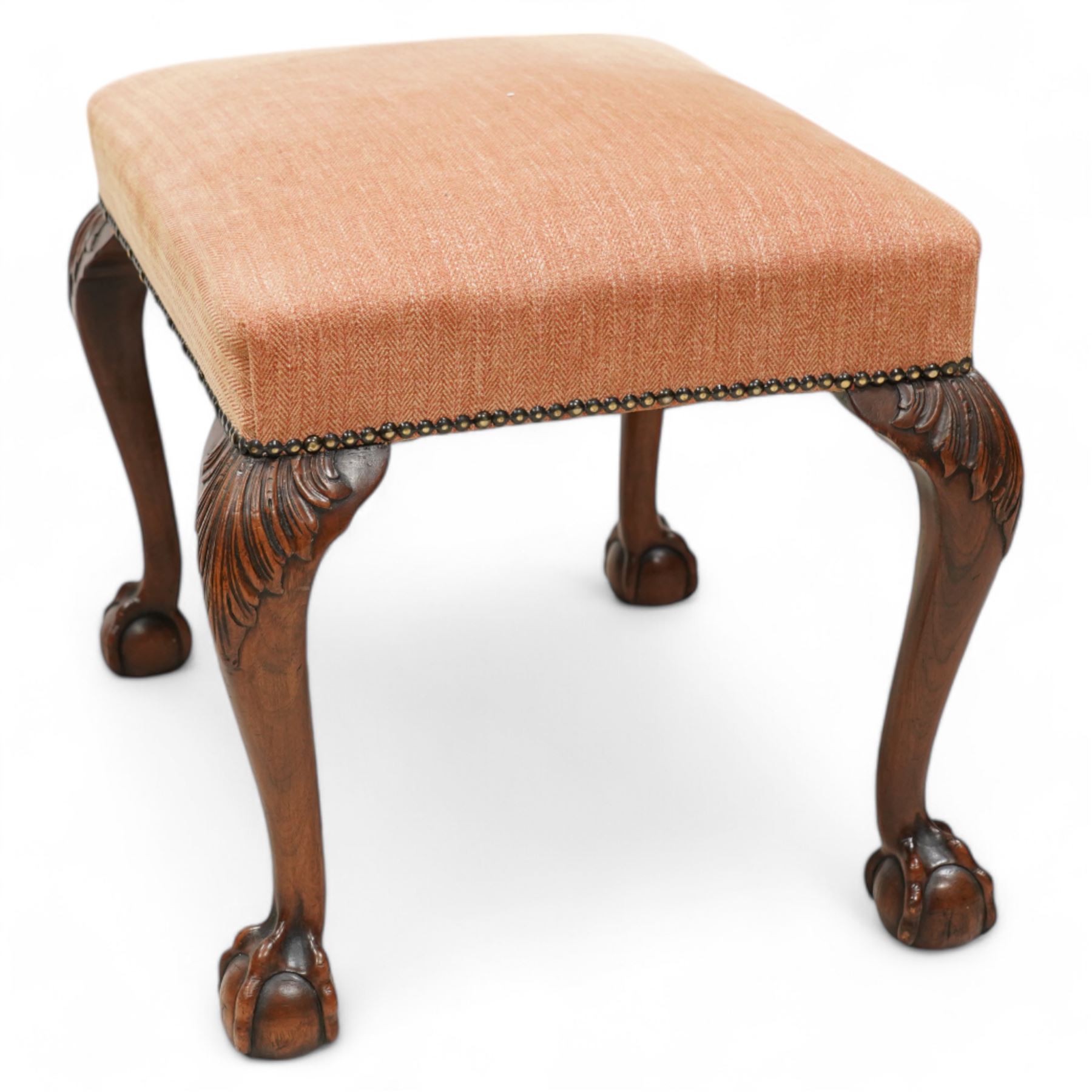 William & Mary design walnut framed armchair, arched cresting rail over rolled arms and C-scrolled arm supports, upholstered in peach herringbone fabric with contrasting rouge twist piping, on turned front feet with scrolled terminals, united by shaped and moulded X-frame stretchers with turned finial (W80cm, H106cm, D80cm); together with a Georgian design mahogany footstool, in matching upholstery with stud band, on acanthus leaf carved cabriole supports with ball and claw feet (60cm x 47cm, H47cm)