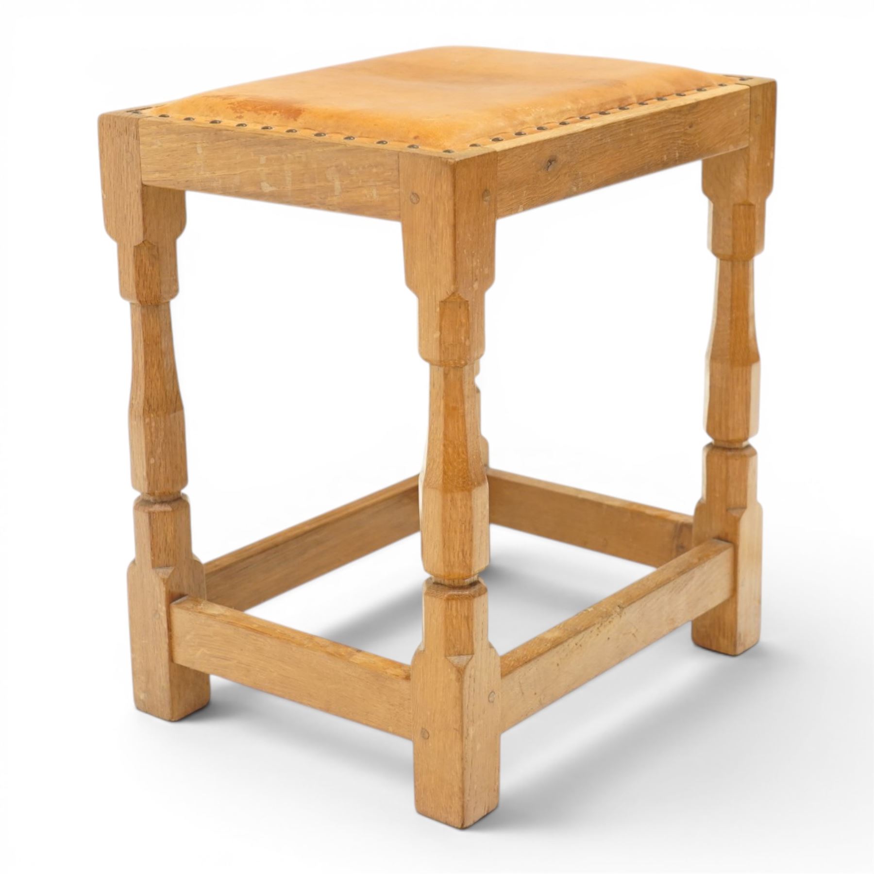 Mouseman - oak dressing table stool, the rectangular tan leather padded seat with studwork border, raised on octagonal supports united by box stretcher, carved with mouse signature, by the workshop of Robert Thompson of Kilburn