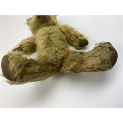 Early 20th century English teddy bear, WW1 period, with wood wool filled mohair body, fixed head with one boot button eye and vertically stitched nose and mouth and jointed limbs with cloth paw pads H16