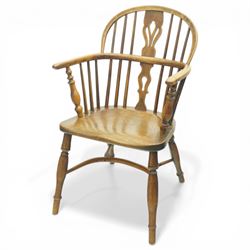 19th century low back elm Windsor armchair, hooped back with pierced central splat and radiating spindles, shaped arm bow over saddle seat, on turned supports united by crinoline stretcher