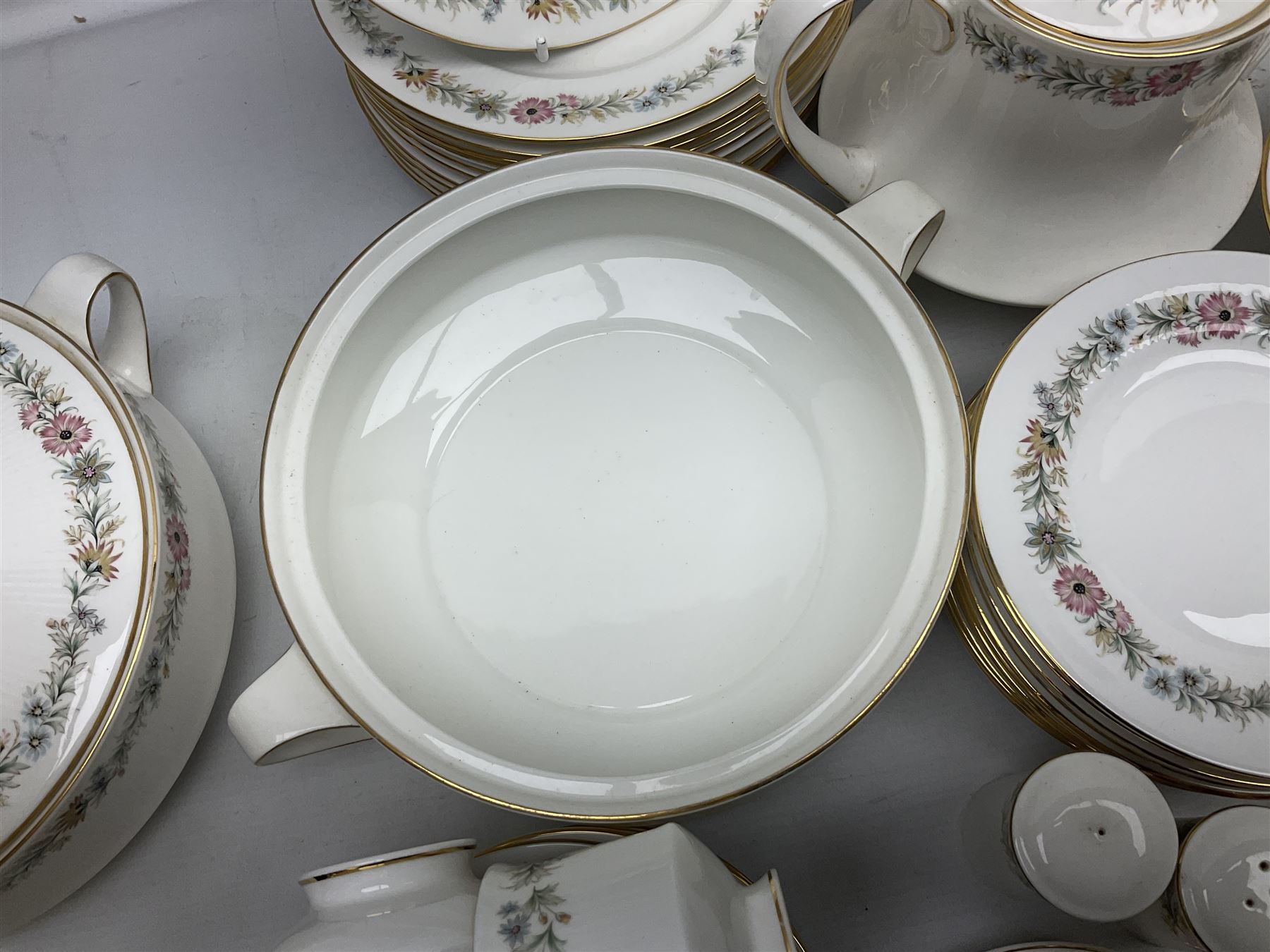 Royal Albert Paragon tea and dinner service for twelve decorated in the Belinda pattern, comprising fourteen saucers, twelve teacups, thirteen side plates, teapot, sauce boat and stand, salt and pepper shakers, two jugs, sucrier, twelve dinner plates, twelve smaller plates, two lidded tureens, twelve bowls, twelve smaller bowls, cake plate, oval plate and oval dish (100)