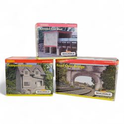 Fourteen Hornby Skaledale 00 gauge model railway trackside buildings, comprising R8504 Holly Farm Cottages, R8501 Ravenn Cottage, R8655 Lock Side Stores, R8550 Ticklepenny Cottage, R8719 Lower Skaledale Waiting Room, R8602 Holly Farm Barn, two R8633 Covered Coal Shed, R8525 Holly Farm Stables, R8629 Station Building, R8571 Road Over Bridge, R8856 Skaledale East Waiting Room, R8990 Cricket Pavillion and R8682 Greenhouse, all boxed