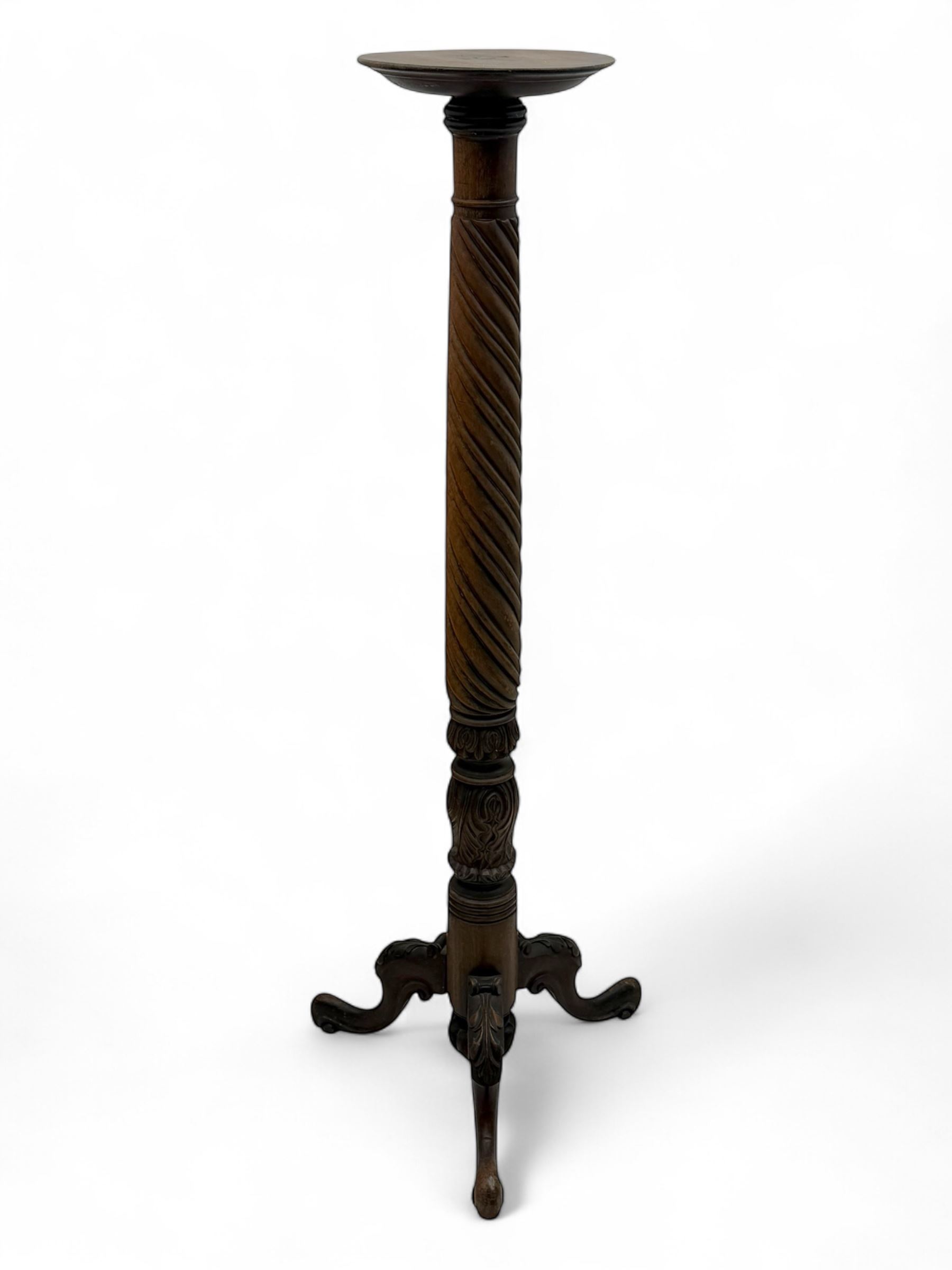 Late 19th century mahogany torchère stand, with circular top above a twisted and foliate carved collumn, on a scroll carved tripod base, on cabriole legs