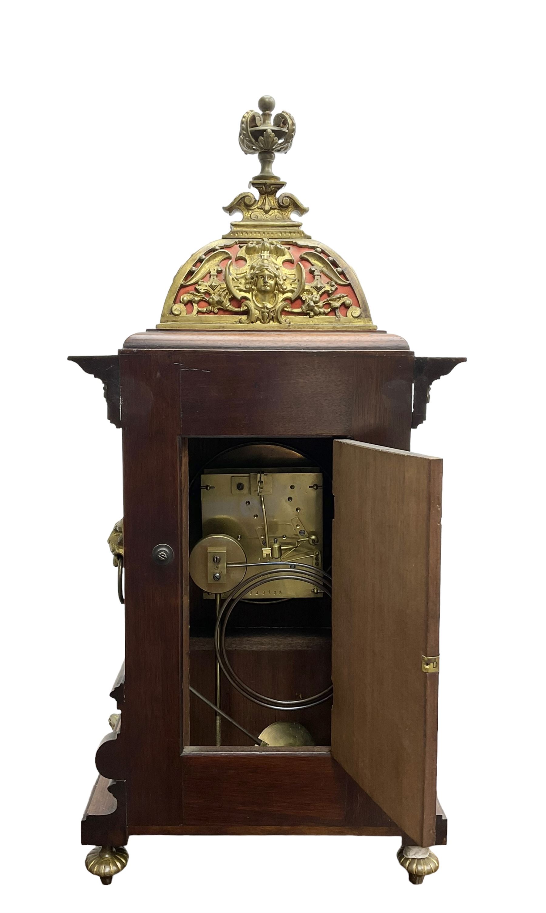 Lenzkirch - Edwardian German 8-day  mantle clock in an oak case with brass mounts and a pierced dome pediment with finial, silvered dial with Arabic numerals, gilt hands and dial centre, rack striking movement, striking the hours and half-hours on a coiled gong. With pendulum and key.
