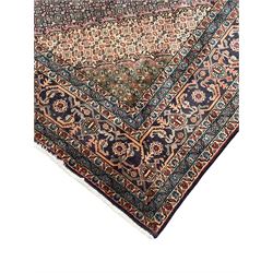 Persian Bidjar peach ground carpet, central pole medallion enclosed within lozenge field and spandrels, decorated all over with small Heratti motifs, the main border with trailing pattern decorated with stylised plant and Boteh motifs, within two triple band guard stripes with repeating flower head decoration 