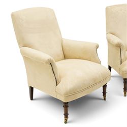 Sofas & Stuff - pair of ‘Thistle’ armchairs upholstered in neutral fabric, each with gently sloping back, padded scroll arms with close-set stud detailing, loose seat cushions, raised on turned wooden legs with brass castors