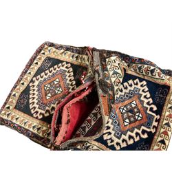 Antique Persian red ground saddle bag, decorated with all-over Boteh motifs, geometric patterned border (127cm x 68cm); Persian indigo ground saddle bag, decorated with two geometric ivory lozenges (113cm x 62cm); Persian red ground saddle bag decorated with lozenges and multi-band border (110cm x 65cm) 