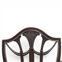Set of eight George III style mahogany dining chairs, comprising two carvers and six singles, each with shaped top rail above pierced splay carved with feathers, with drop in stuffover seats upholstered in blue striped fabric, raised upon square tapering legs joined by stretchers, together with a mahogany twin pedestal dining table, the oval top with central leaf raised upon turned columns and splayed reeded legs terminating in lion paw feet and brass castors, 
