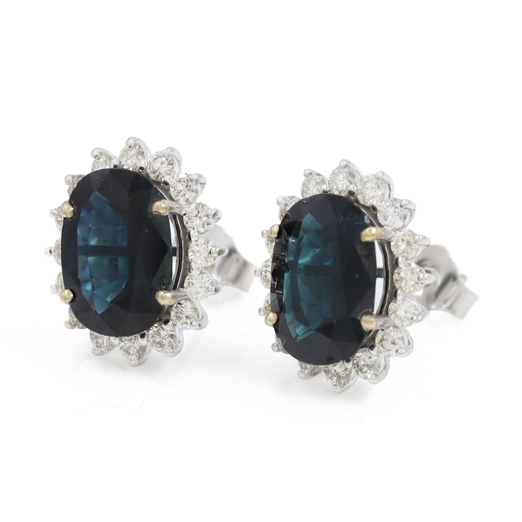 Pair of 18ct white gold sapphire and diamond cluster earrings, each stud set with a single oval cut sapphire, surrounded by sixteen round brilliant cut diamonds, total sapphire weight approx 6.65 carat, total diamond weight approx 1.00 carat