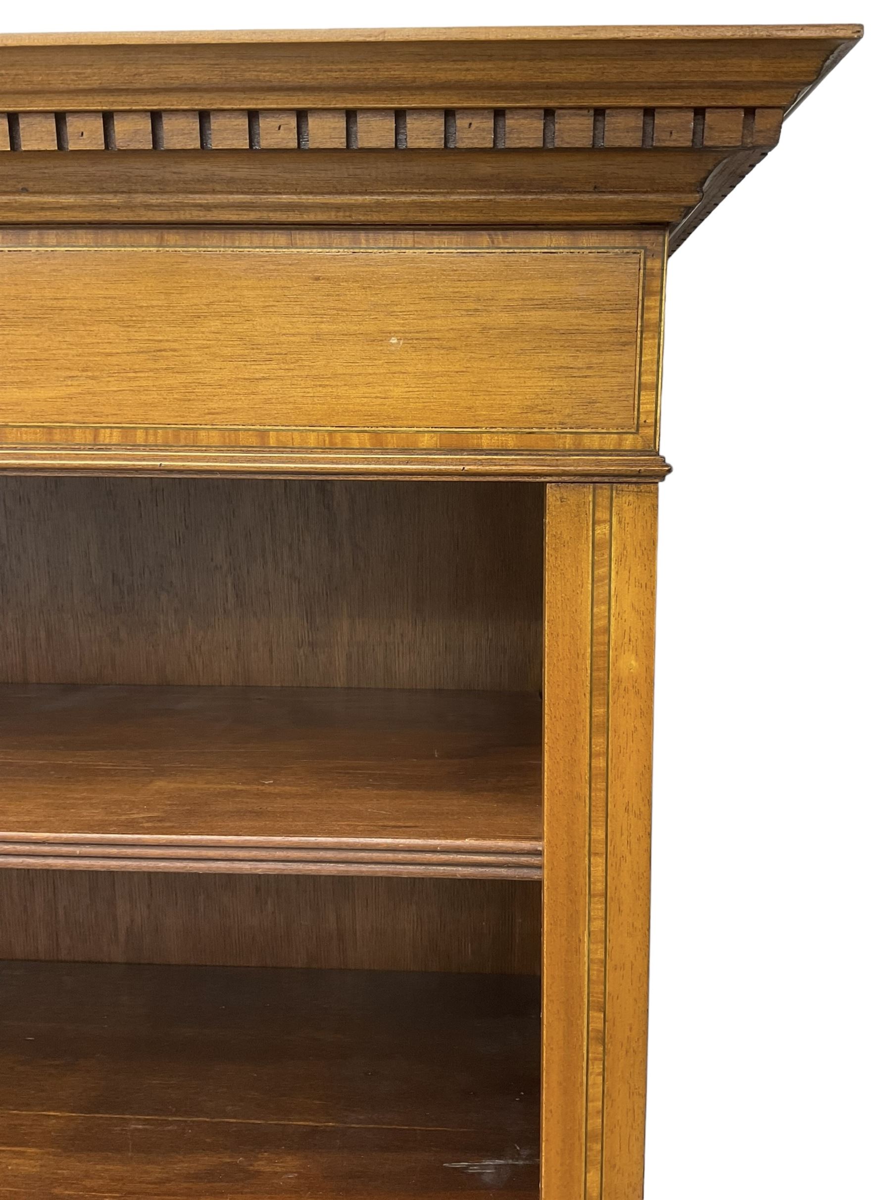 Edwardian inlaid mahogany open bookcase, projecting dentil cornice over crossbanded frieze, fitted with four adjustable shelves with reeded facias, on skirted base