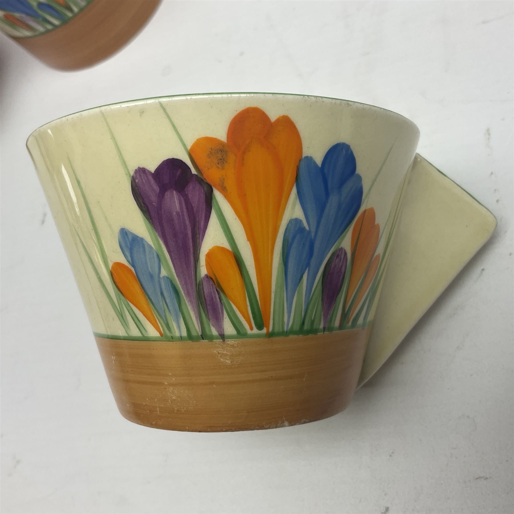 Clarice Cliff for Newport Pottery ceramics, comprising preserve jar and Bon Jour shape teacup, both in Crocus pattern, together with a Clarice Cliff for Wilkinson Ltd, preserve jar with cover, in Gayday pattern, preserve jar H10cm