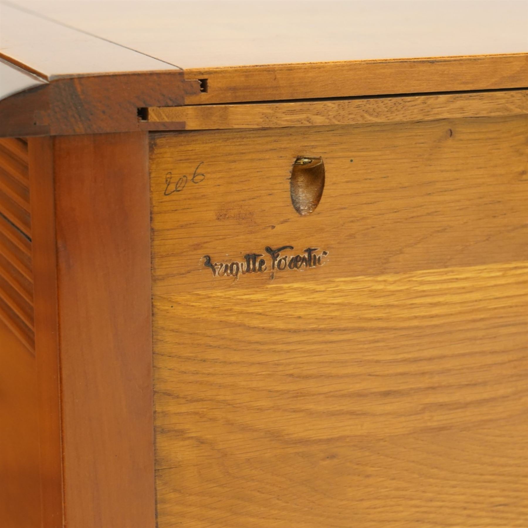 Brigitte Forestier - pair of cherry wood bedside cabinets, moulded rectangular top above two drawers, the top drawer with reeded panels flanking a brass circular pull, the lower drawer with two brass pulls, on square tapering supports united by a full length undertier