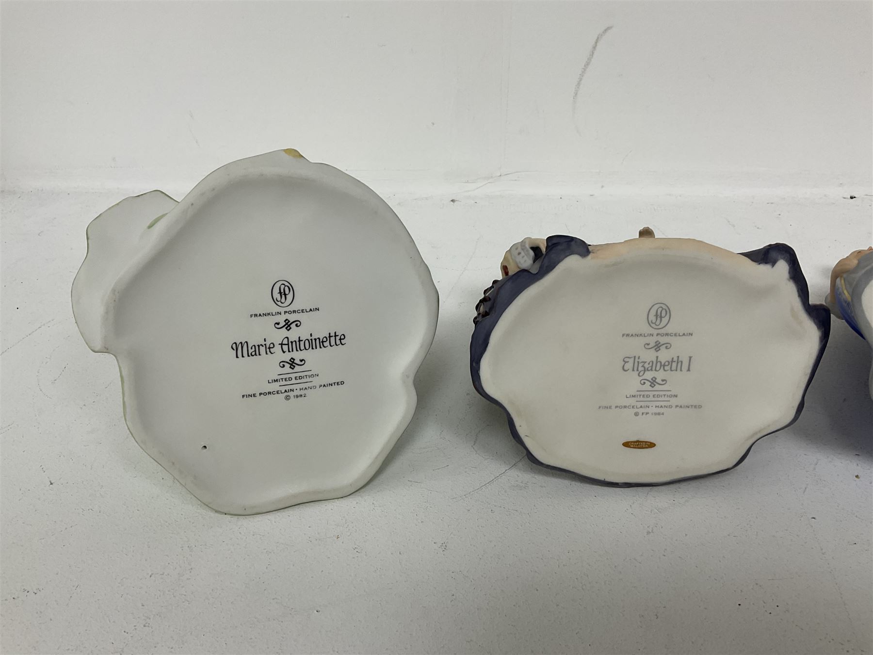 Four limited edition Franklin Mint figures of queens comprising Elizabeth I, Isabella of Spain, Catherine the Great and Marie Antoinette