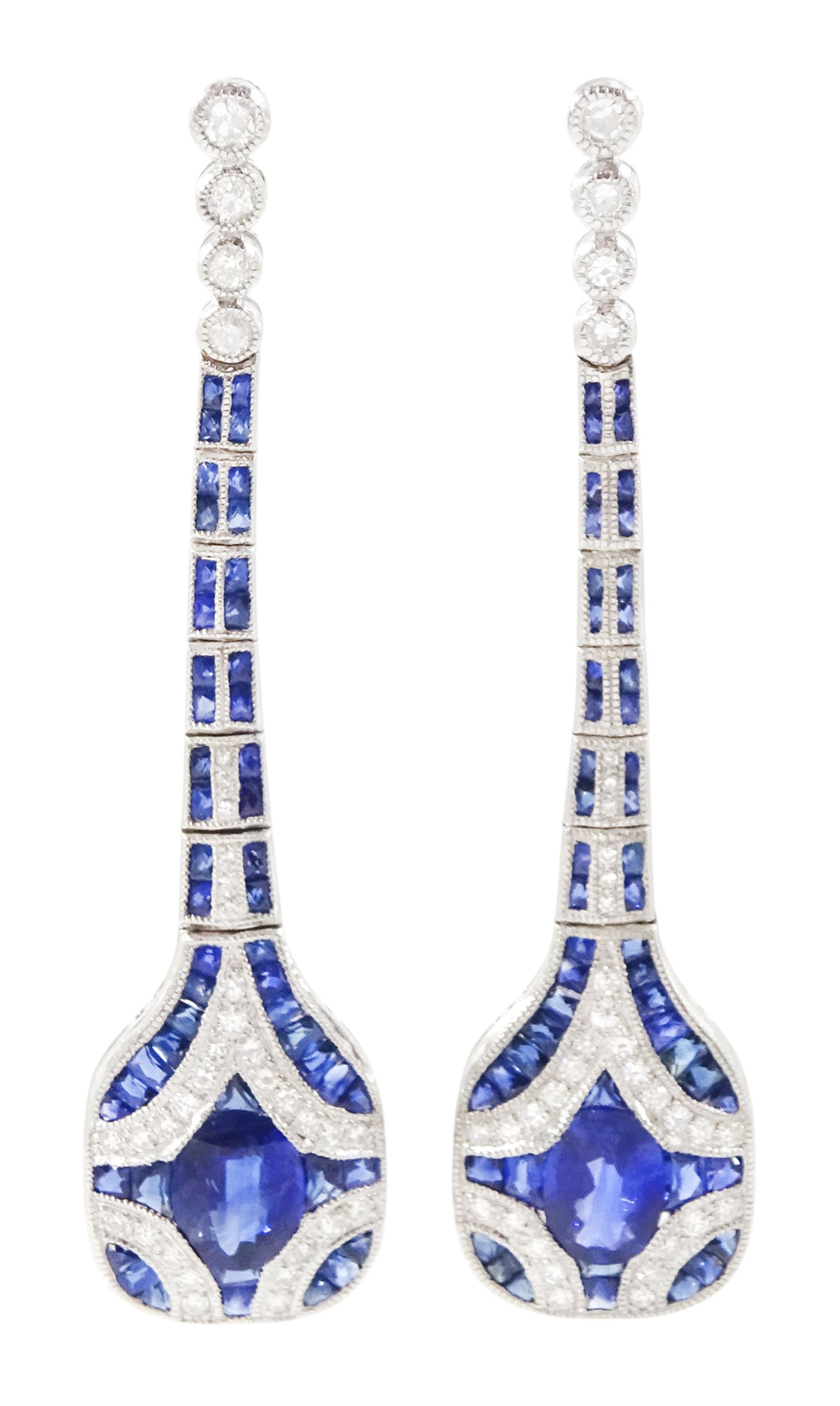 Pair of platinum sapphire and diamond pendant earrings, each stud milgrain set with a single oval cut sapphire, surrounded by calibre cut sapphires and single cut diamonds, suspending from six graduating articulated panels, to four single cut diamonds, total sapphire weight approx 3.80 carat, total diamond weight approx 0.80 carat
