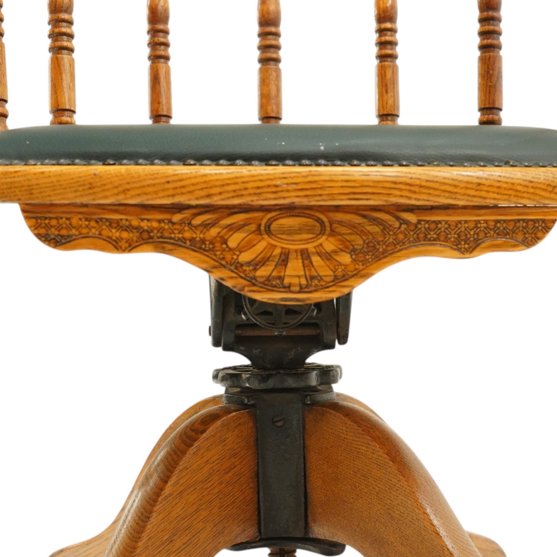 Edwardian oak captains swivel desk chair of tub form, shaped cresting rail over spindle supports and green-leather upholstered seat, foliate apron over swivel action and four-spoke base