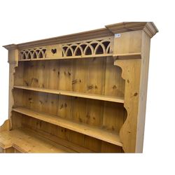 Large traditional pine 'dog kennel' dresser, projecting cornice over pierced arch design frieze and two-tier plate rack, breakfront base fitted with five drawers and two cupboards with central recess and removable gate
