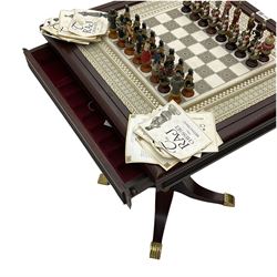 Franklin Mint Indian ' The Raj ' chess set with marble effect chess board within a mahogany stained frame raised on a brass mounted pedestal base with single fitted drawer, the playing pieces depicting figures from the 1857 Raj mutiny 52cm square H68cm