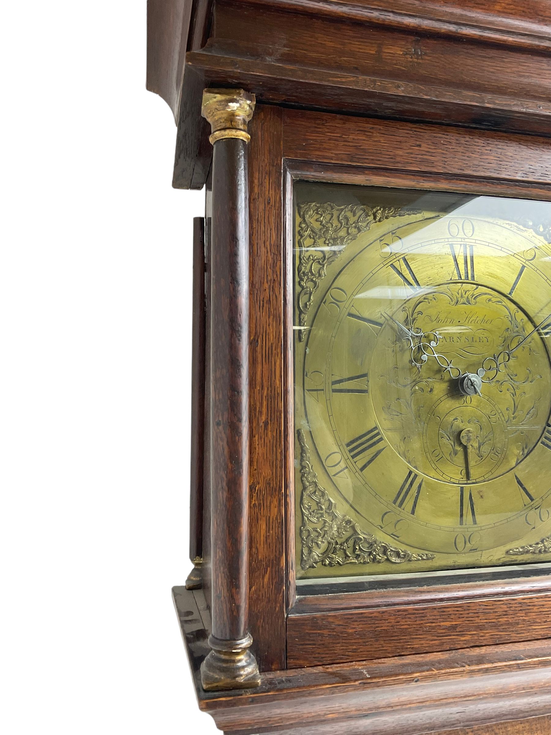John Fletcher of Barnsley - Mid18th century 30-hour oak cased longcase clock, with a flat pediment and broad cornice, square hood door with attached pillars and gesso capitals, long trunk and conforming door with a break arch top, square plinth on a shaped base, brass dial with cast spandrels and engraved dial centre, chapter ring with Roman numerals and five minute Arabic’s, engraved calendar dial and steel hands, chain driven count wheel movement striking the hours on a bell. With pendulum and weight. The Fletcher family were a prolific family of clockmakers working in Barnsley (Yorks) during the 18th and early 19th century.