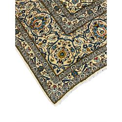 Persian Kashan golden ivory ground carpet, the central medallion surrounded by a field of interlacing branch and stylised plant motifs, the guarded border with scrolling design decorated with flower heads 
