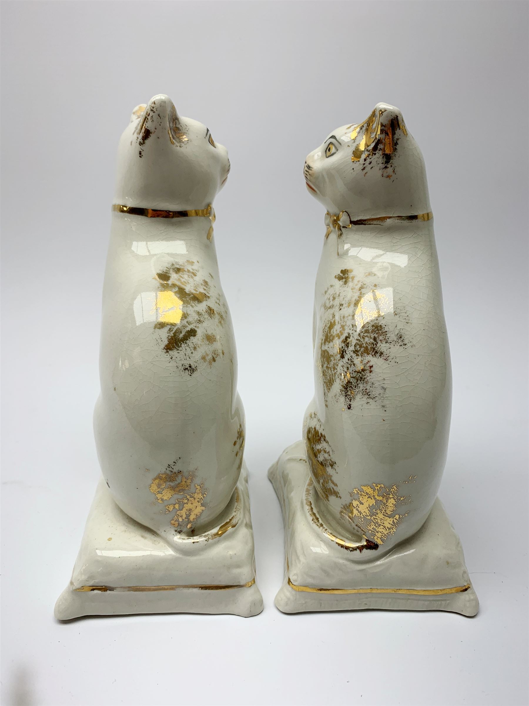 Pair of Victorian Staffordshire cats, modelled seated upon cushions, with gilt detail throughout, H18cm