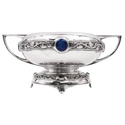 Art Nouveau silver twin handled rose bowl, with repousse rambling rose leaf border, inset with four blue circular enamel cabochons, upon footed pedestal with conforming border and four green oval enamel cabochons, hallmarked Walker & Hall, Sheffield 1908, including handles H13cm, approximate total weight 26.94 ozt (837.7 grams)
