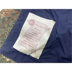 Three tapestries comprising 20th century wool tapestry panel of a medieval nobleman upon a horse with a castle in the distance, together with a smaller tapestry depicting The English Coat of Arms, both hung on rails, and further depicting village scene, largest approx 132cm x 95cm