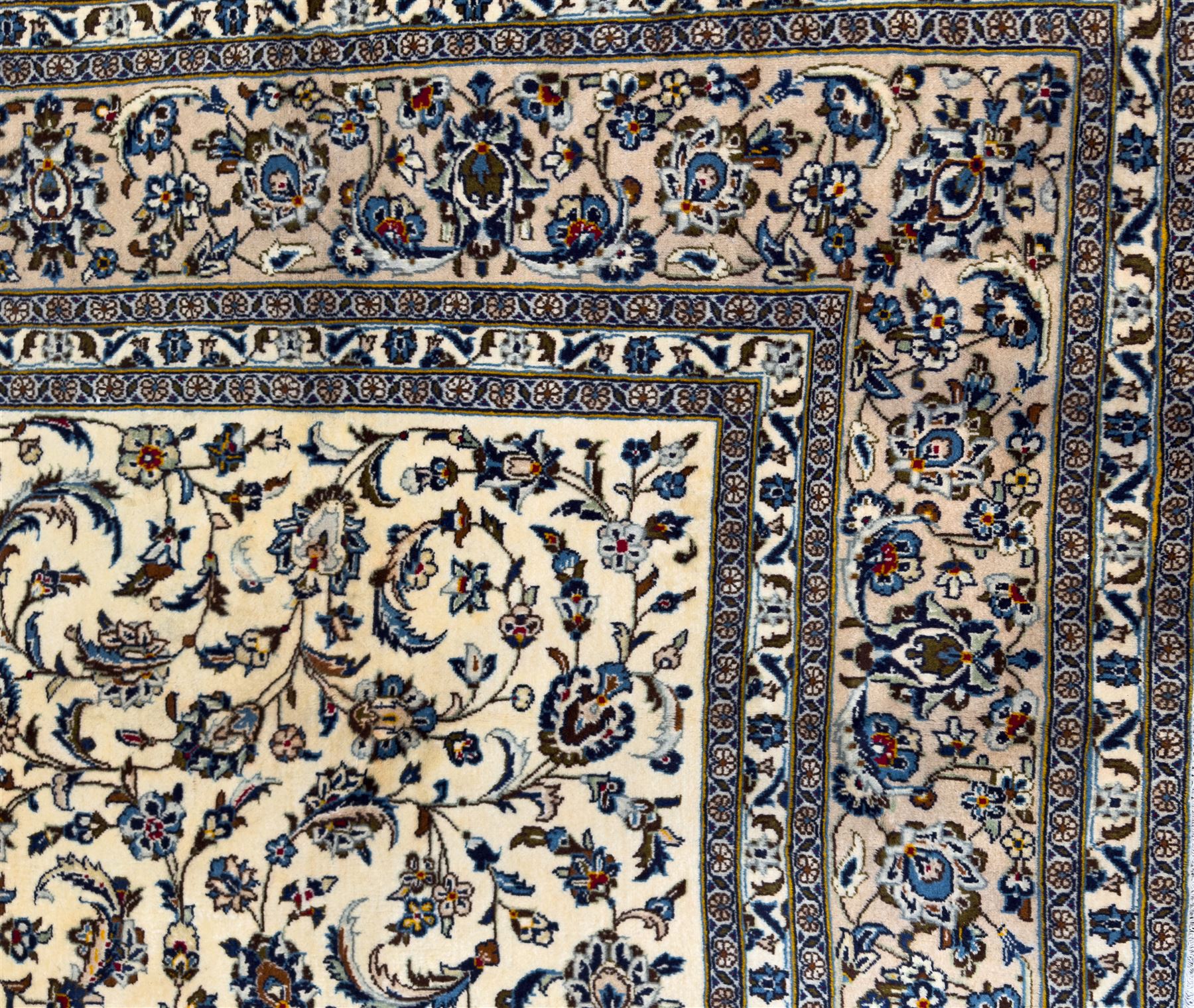 Central Persian Kashan hand-knotted carpet, ivory field with an all-over design of scrolling vines, lotus palmettes, and rosettes in shades of blue and brown within a blue ground border of palmettes and arabesques between multiple guard stripes, 
348 cm x 246cm