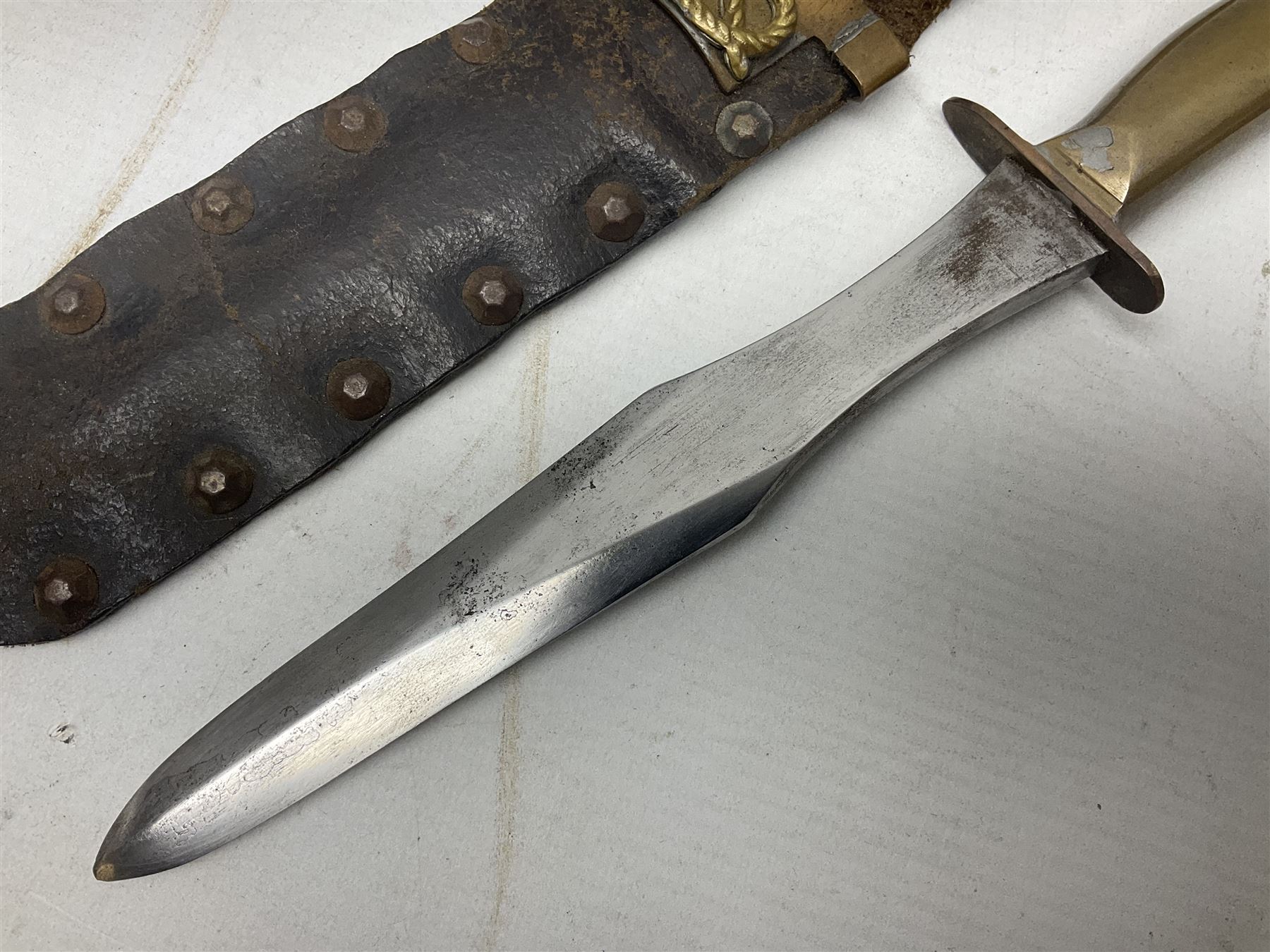 Scratch-built fighting/throwing knife, probably trench art, with 18cm steel spear type blade, plain cross-piece and French Lebel Rifle bayonet grip; in bras mounted studded leather sheath with belt hanger L29.5cm overall