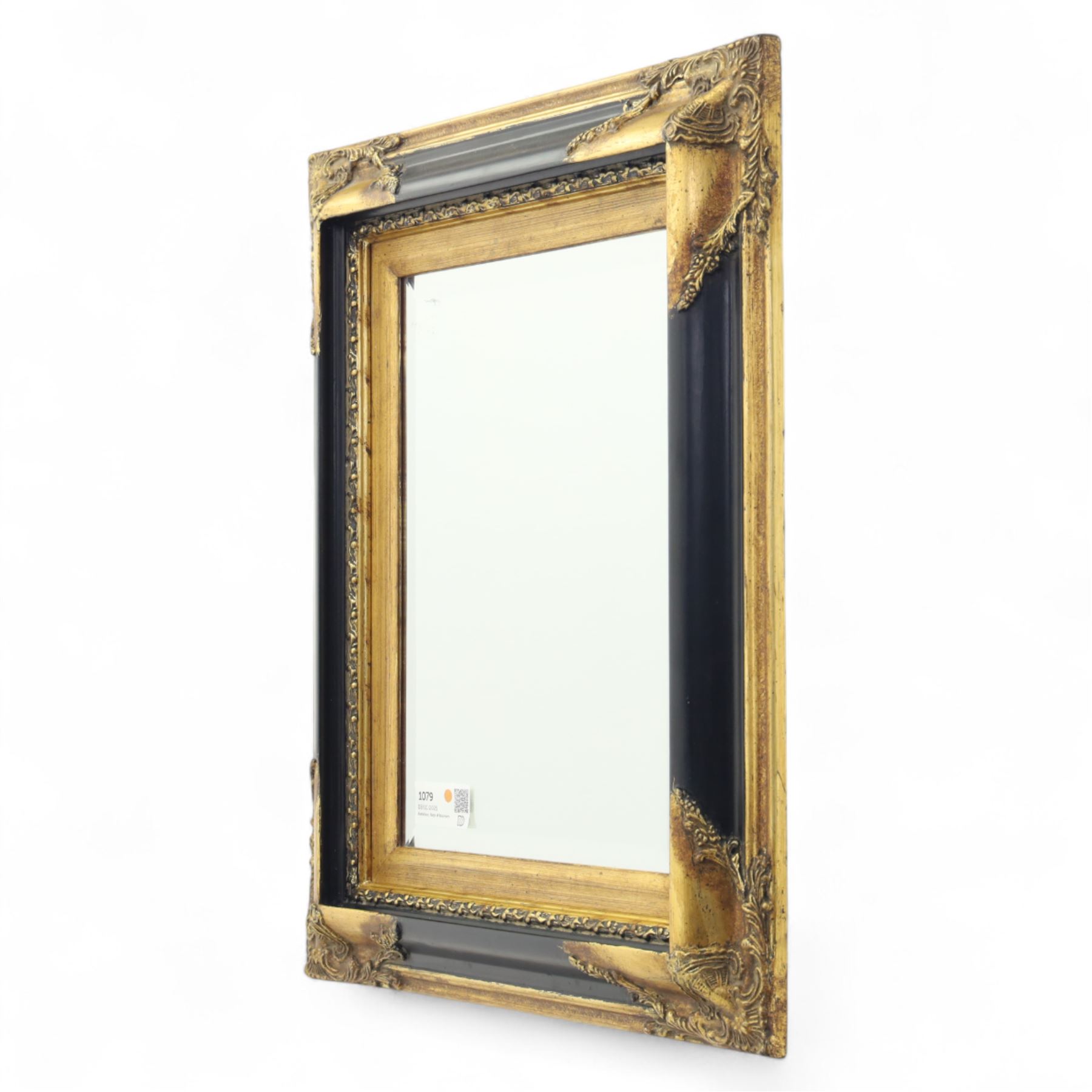 19th century design rectangular wall mirror, set within a swept giltwood and gesso frame, with foliate corner mounts and ebonised inner border, enclosing a bevelled mirror plate