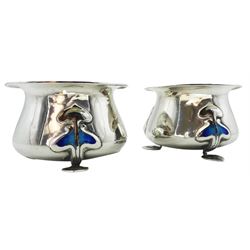 Pair of early 20th century Art Nouveau silver and enamel open salts, of bellied form with lipped rim, upon three stylised pad feet with blue enamel stylised tendril mounts, hallmarked James Fenton, Birmingham 1905, H3cm, approximate weight 1.49 ozt (46.4 grams)