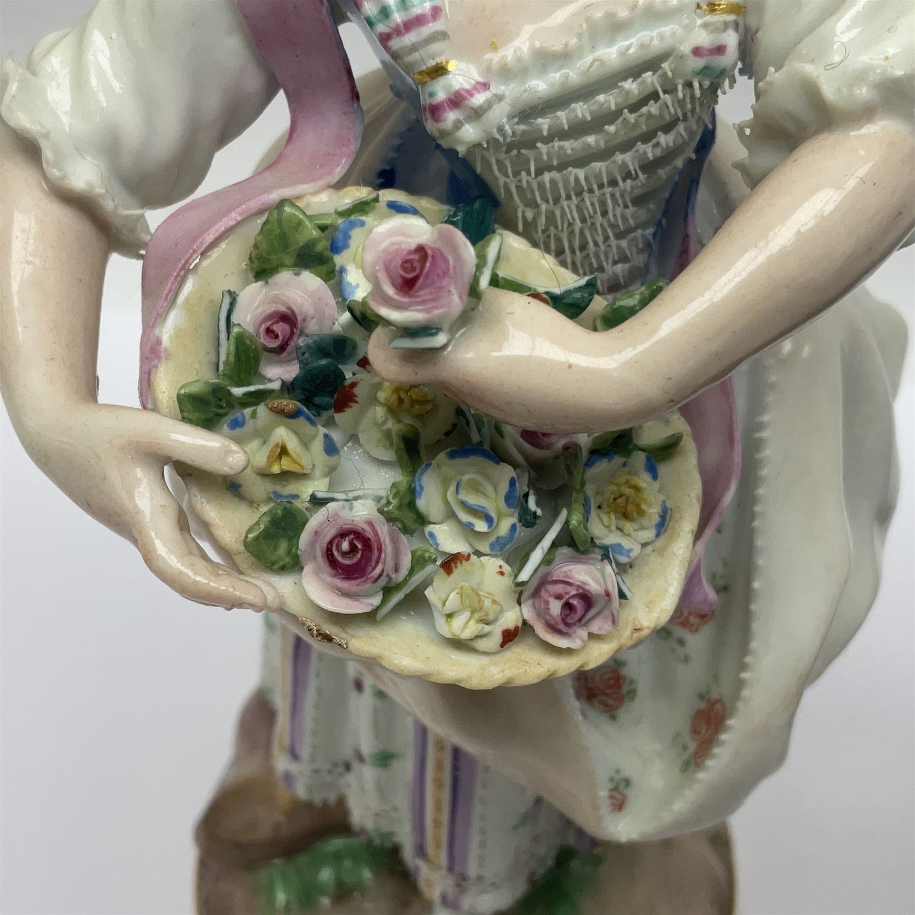 Pair of late 19th/early 20th Century Meissen figures, modelled as flower sellers, after the original by Michel Victor Acier, she holding basket of flowers, he holding flowers in his hat, each with underglaze cross swords mark beneath, tallest H16.5cm