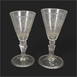 Two 18th century Continental facet cut drinking glasses, each with funnel bowl engraved with armorial type cartouche, upon a knopped and facet cut stem with internal elongated tear, and spreading folded foot, largest H15.5cm