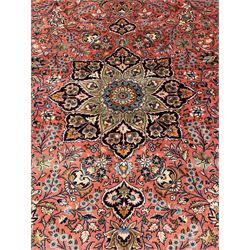 Persian Kashan peach ground rug, central rosette medallion surrounded by trailing branches and flower heads with bird motifs, light blue spandrels with further floral decoration, the main border with repeating palmettes and birds, within guard stripes