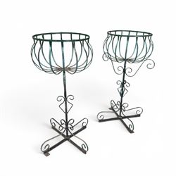 Matched pair of antique metal plant stands, each with circular strapwork basket tops, the ...