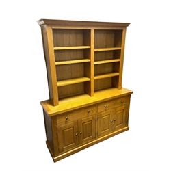 Oak bookcase on sideboard, fitted with six adjustable shelves, lower section with two drawers over two panelled double cupboards, retailed by Alexander Ellis of Beverley