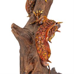 Modern Chinese root carving, modelled as a dragon wrapped round a tree, the dragon painted in greens and reds, H70cm