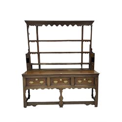 George III oak dresser, projecting cornice over shaped frieze, fitted with three plate racks, the bottom section with rectangular top over three drawers with brass handles, raised on silhouette supports united by stretchers