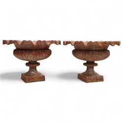 Pair of cast iron garden urns, each of flared form with crinkled edge rims and circular bodies, finished in aged red paint and raised on square bases