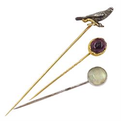 Three Victorian stick pins including silver and gold falcon / kestrel bird, gold cabochon garnet and silver carved 'Man in the Moon' moonstone