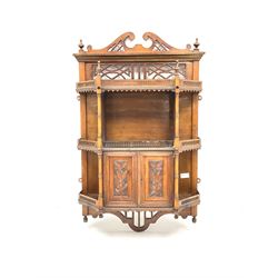 Early 20th century mahogany wall hanging cabinet, pierced swan neck moulding, three shelves above and flanking single cupboard door 