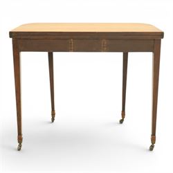 Regency mahogany fold-over tea table, rounded rectangular top with gateleg action, inlaid and crossbanded frieze, raised on squared tapering supports on brass castors