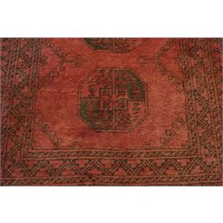 Antique Persian Bokhara red ground runner rug, repeating Gul pattern, surrounded by borders, with fringed ends
