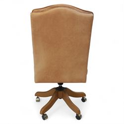 Late 20th century swivel executive desk chair, upholstered in tan leather with brass studded trim, raised on five point base raised on castors 