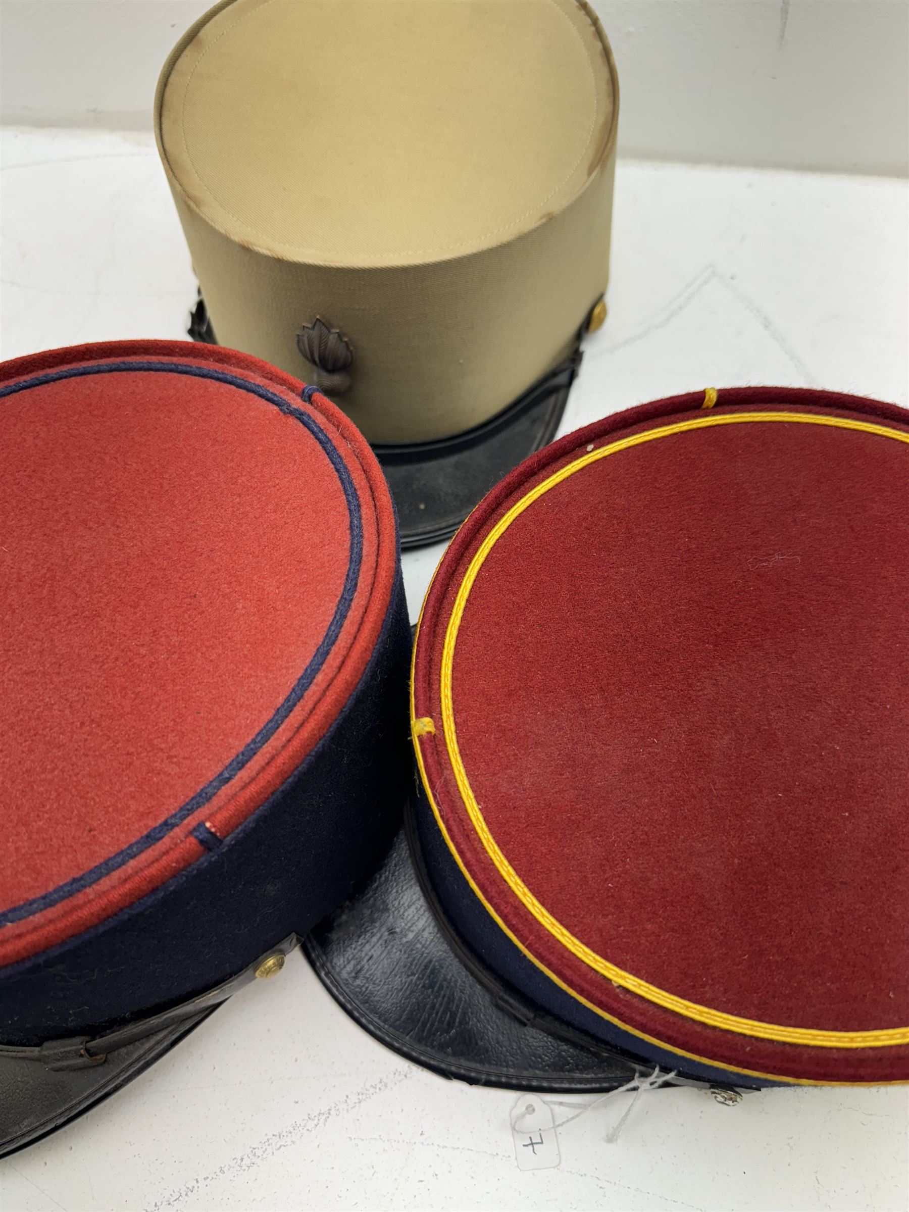 Three French Foreign Legion Kepis; two infantry examples and the third Calvary, each with black peak, original leather sweatband and markers mark stamped inside 