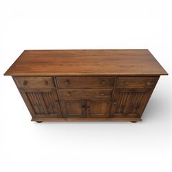 Ercol - elm dresser sideboard, fitted with four drawers and four cupboards with carved detail, drawer featuring cutlery slide