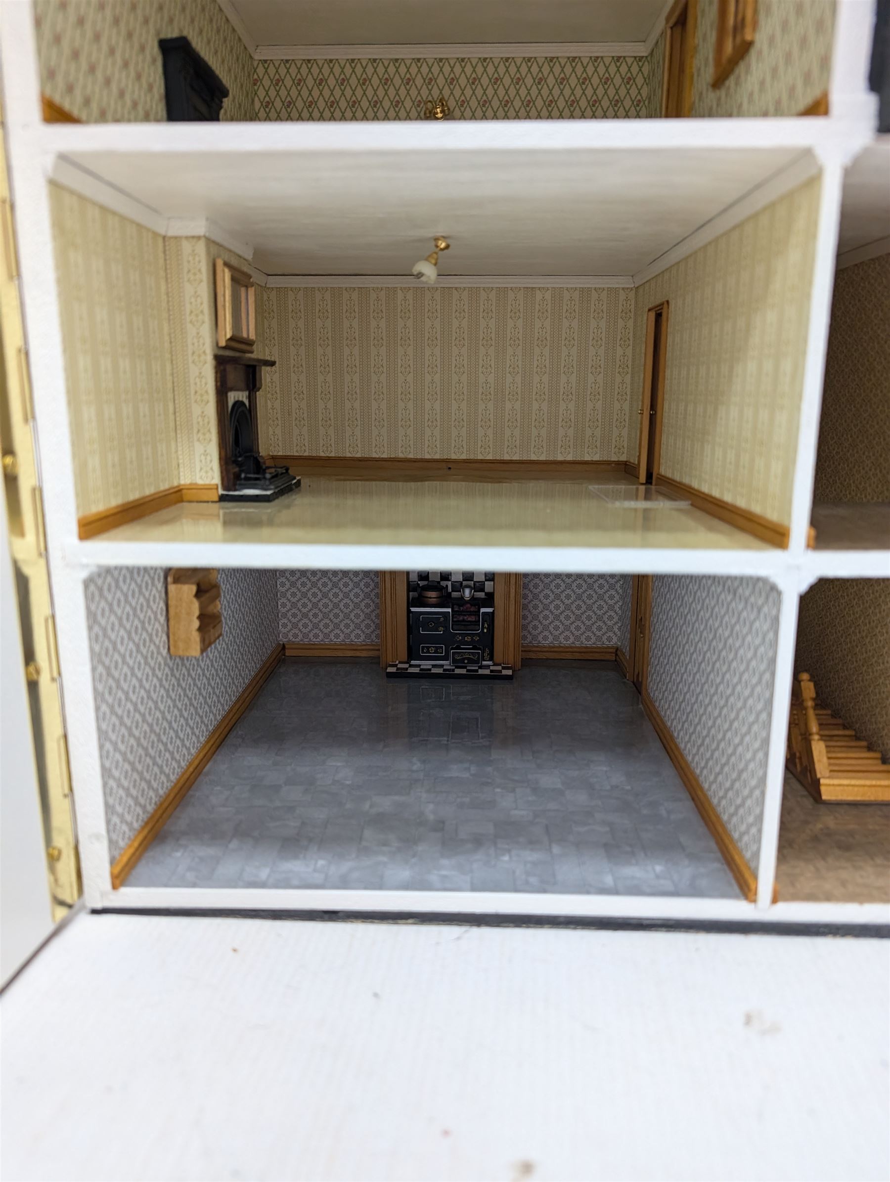 1:24 scale four-storey tudor-style dolls house, with black and white exterior, balcony garden, glazed panelled windows and wooden shingle roof, with decorated interior and wired fireplaces and lighting, H65cm, W58cm, D31cm, 