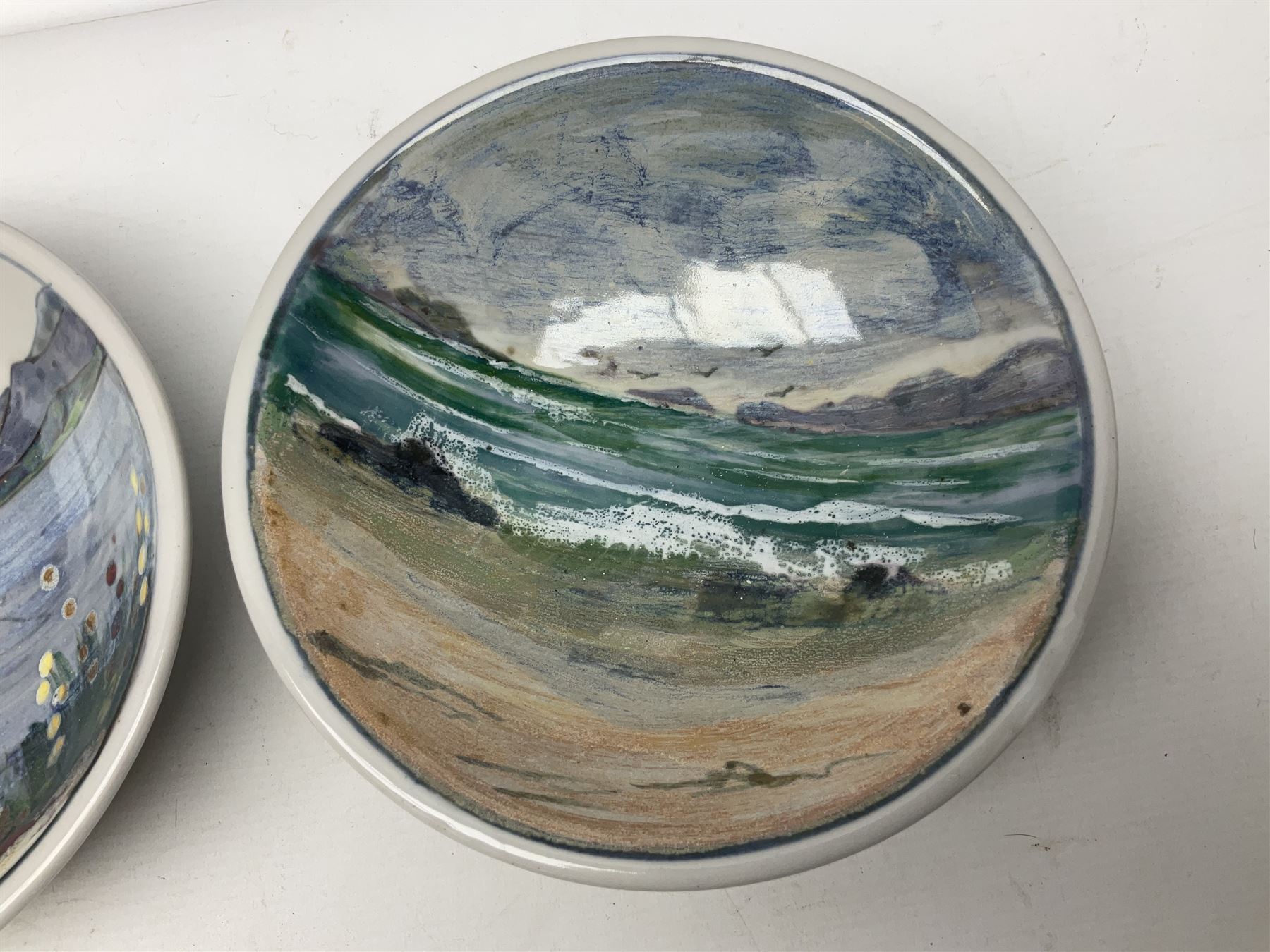 Highland Stoneware Scotland, decorated with landscapes and seascapes, comprising of two bowls, plate and two covered trinket boxes 