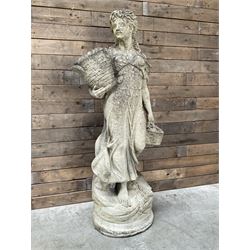 Classical cast stone statue of woman in flowing robes carrying two baskets